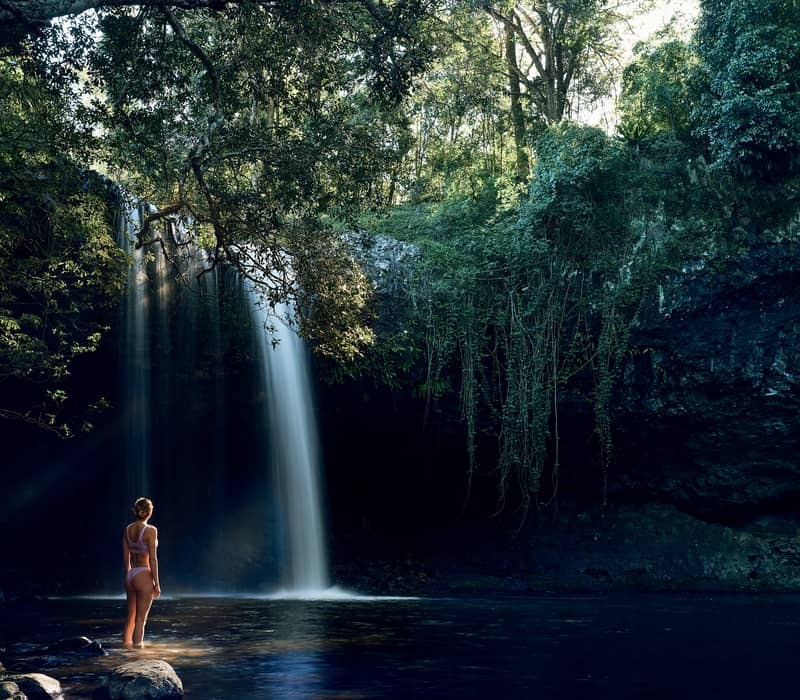 woman in front of waterfall in Newrybar Byron Bay  Sydney Bespoke Tours