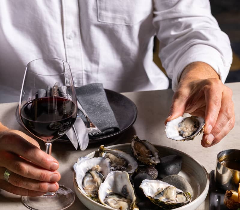 Fresh oysters on ice served with a glass of red wine at a high-end Adelaide restaurant.