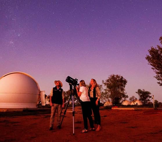 Visitors stargazing at Earth Sanctuary in Australia under a starry sky.