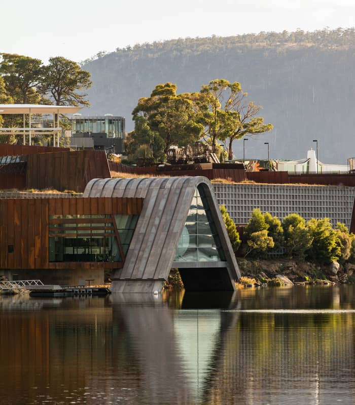 Modern architectural structure of Pharos at Mona museum over the water at sunset.