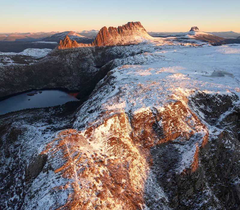 Snow-capped Cradle Mountain peaks reflecting morning light over Dove Lake.