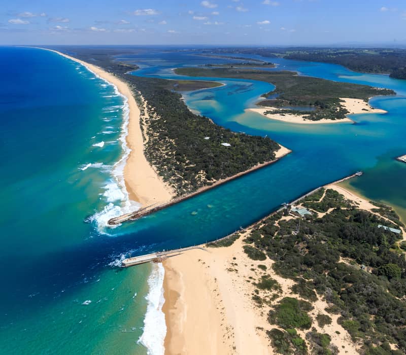 High-angle aerial view of the turquoise waters meeting the sandbar at Lakes Entrance, Victoria.