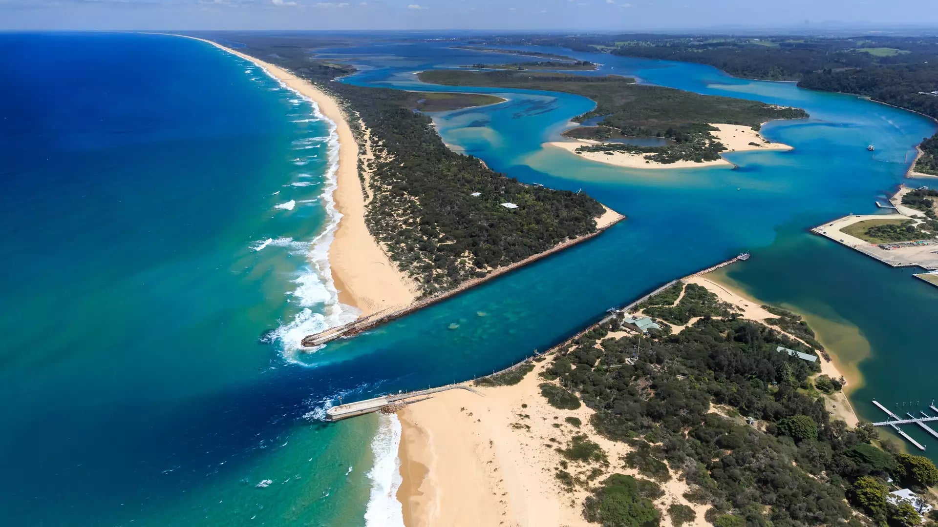 High-angle aerial view of the turquoise waters meeting the sandbar at Lakes Entrance, Victoria.