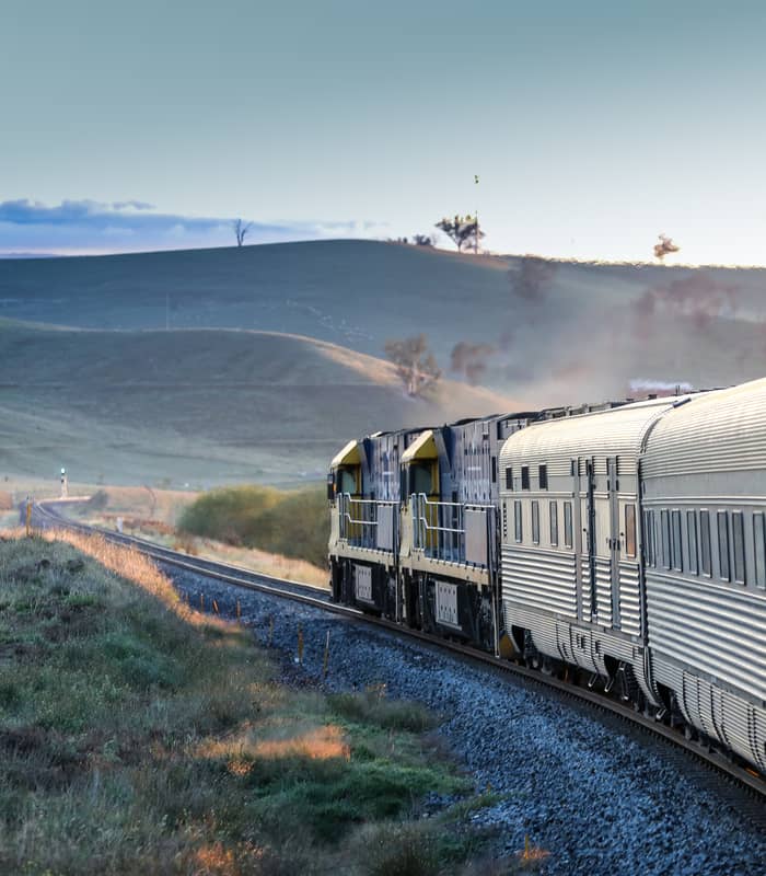 View from the window of the Indian Pacific train as it rounds a curve through the grassy hills of the Blue Mountains, New South Wales.