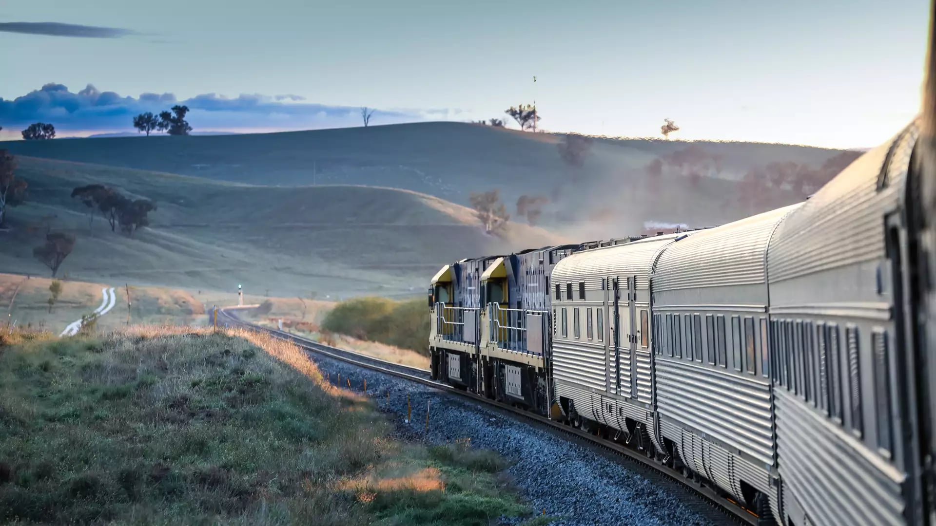 View from the window of the Indian Pacific train as it rounds a curve through the grassy hills of the Blue Mountains, New South Wales.