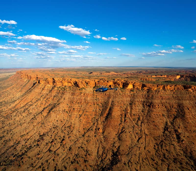 Helicopter scenic flight over the red sandstone cliffs of Kings Canyon in the Northern Territory.