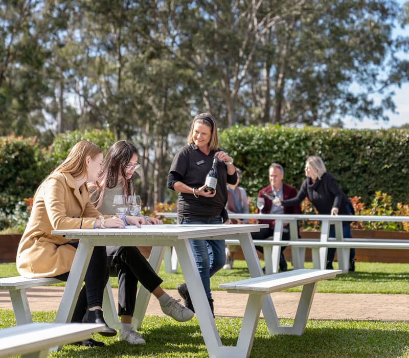 Guests enjoying a guided wine tasting experience at an outdoor vineyard setting in the Hunter Valley, NSW.