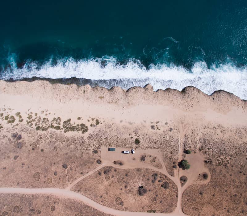 Aerial of the Red Bluff at Quobba Station, where the desert sands meet the Ningaloo Reef.
