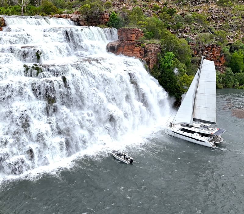 The Eclipse Expeditions catamaran sailing close to the massive rushing waterfalls of Kings Cascade.