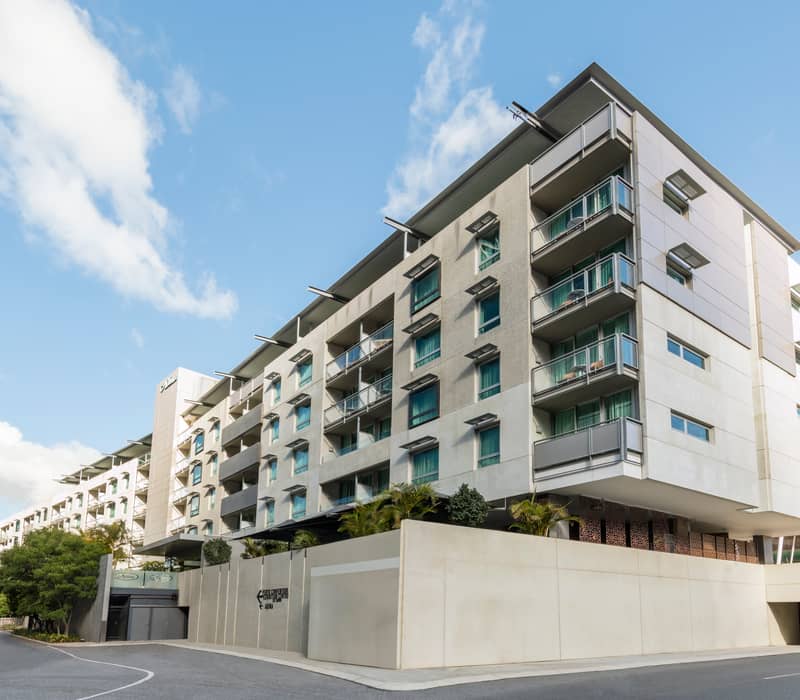 Minimalist studio hotel room with king bed and private balcony in Perth CBD.