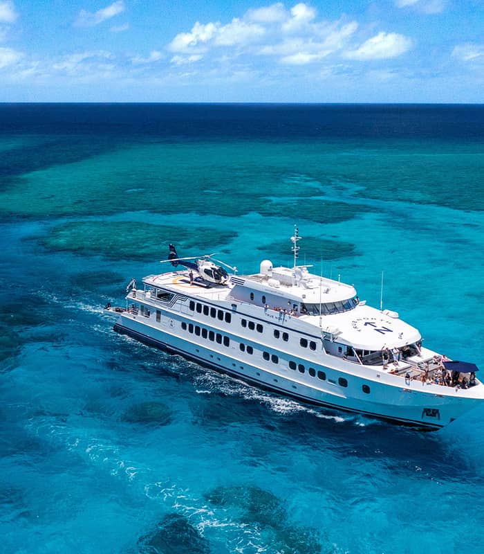 The 50-metre flagship vessel True North navigates the crystal-clear turquoise waters of the Great Barrier Reef. 