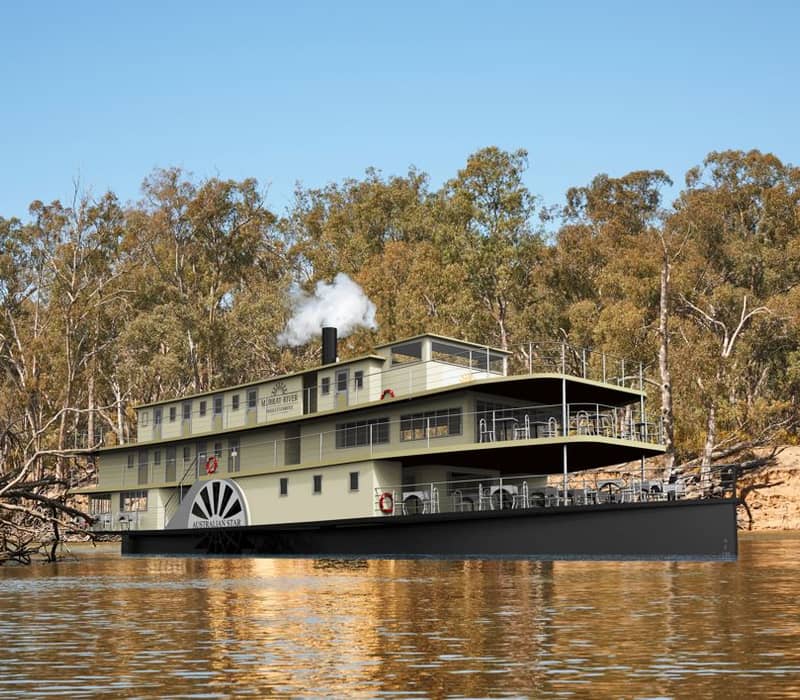 Side view of the PS Australian Star paddle steamer on the Murray River against a forest background.