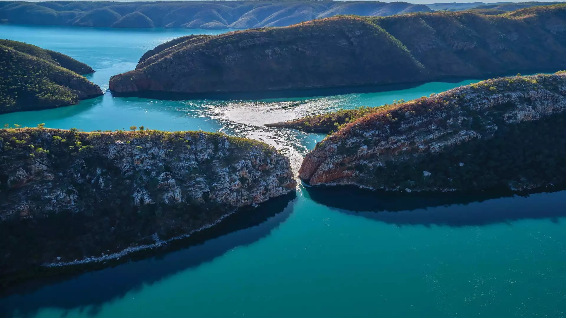 Aerial view of turquoise water rushing through narrow rock gaps at Horizontal Falls in the Kimberley.