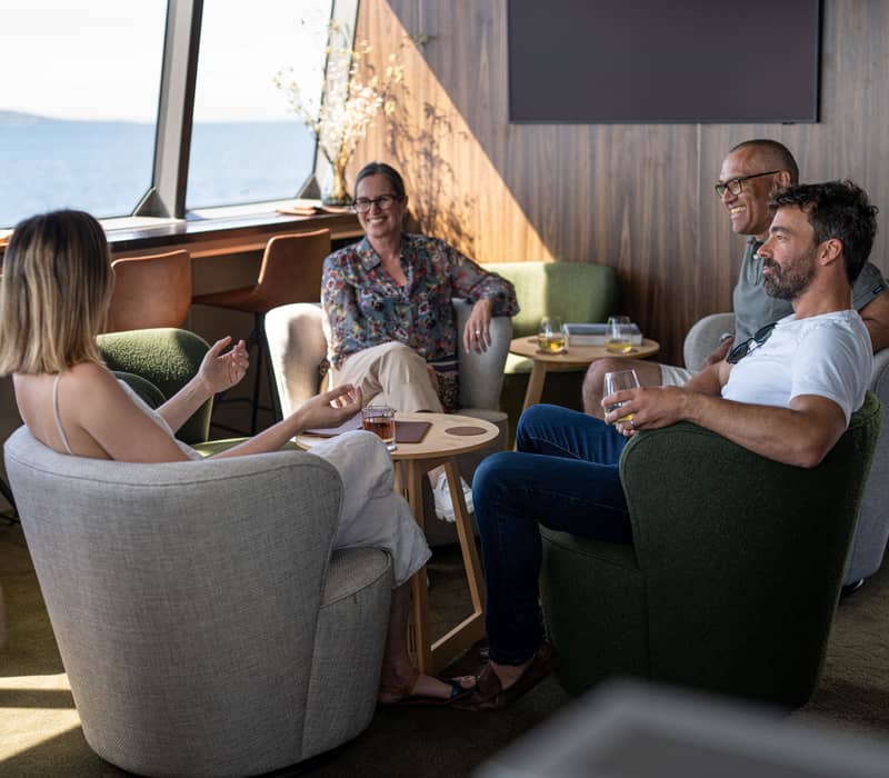 People enjoying drinks in the cabin of On Board Tasmania's small luxury cruise ship