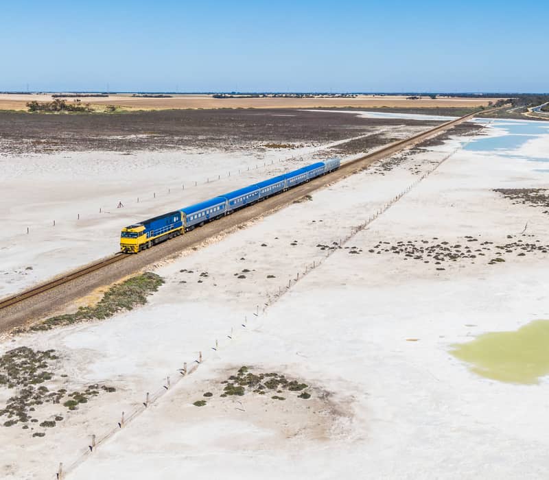 Aerial shot of The Overland Train over salt plains. 