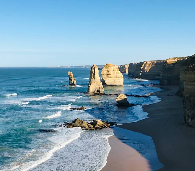 Limestone stacks on the Great Ocean Walk under a clear blue sky.
