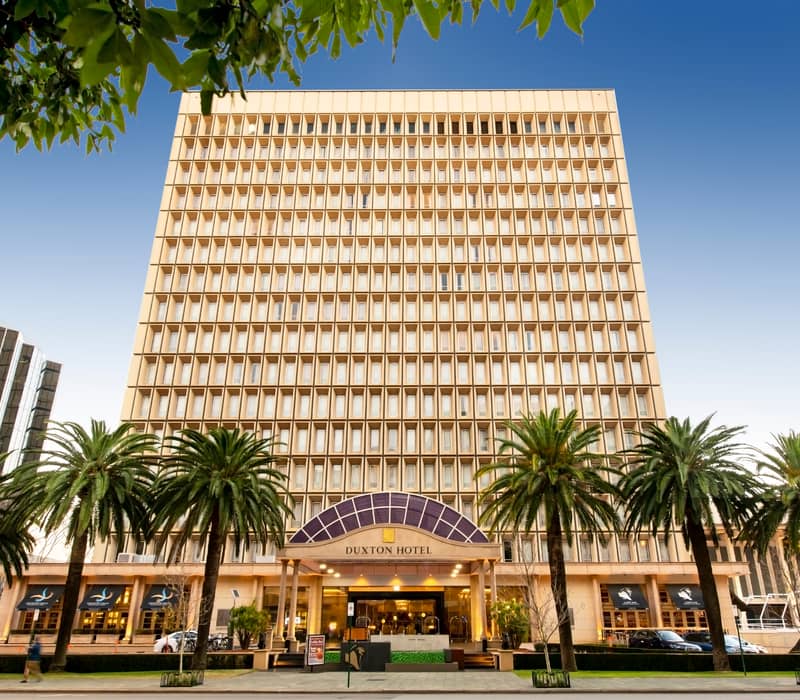 Luxury hotel room with a king bed and large windows overlooking the Swan River in Perth.