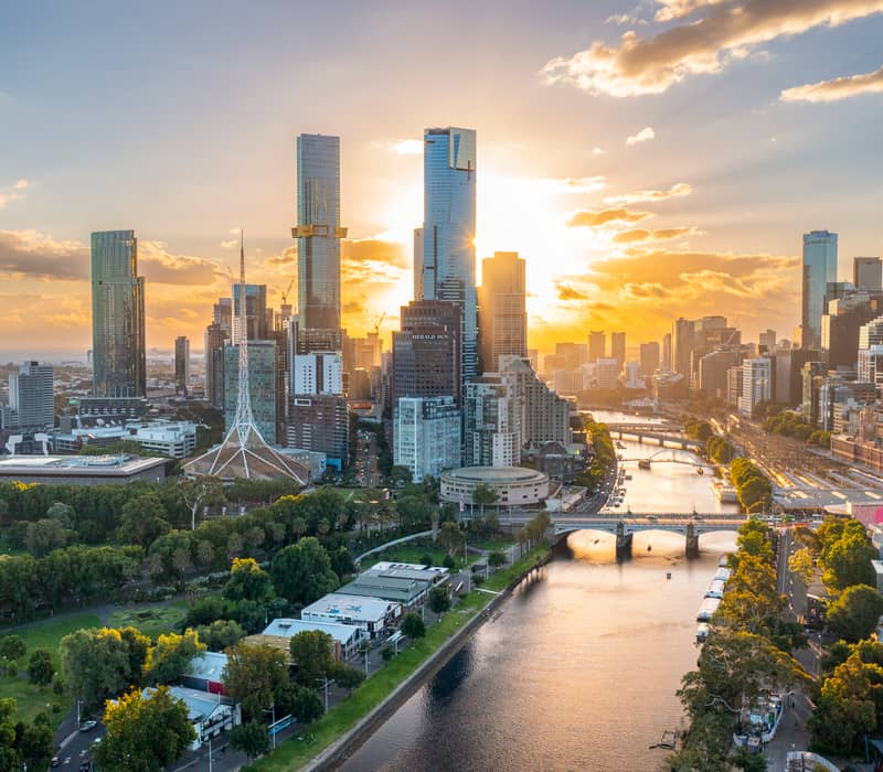 Aerial view of the Melbourne CBD skyline and Yarra River during a golden sunset.