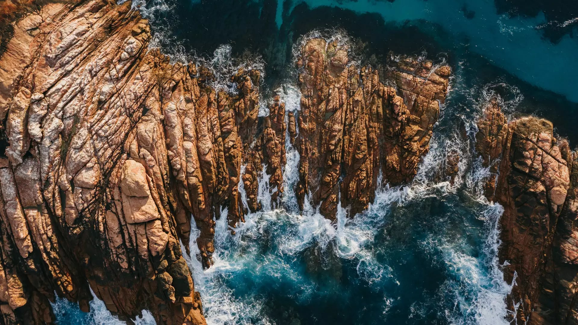 A stunning top-down aerial shot shows the white wash of the Indian Ocean surging through the narrow granite channels of Canal Rocks near Yallingup in the Margaret River region.