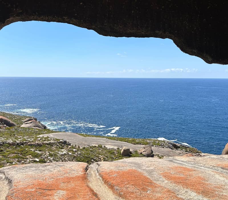 View of the blue Southern Ocean framed by a natural granite rock opening at Remarkable Rocks, Kangaroo Island.