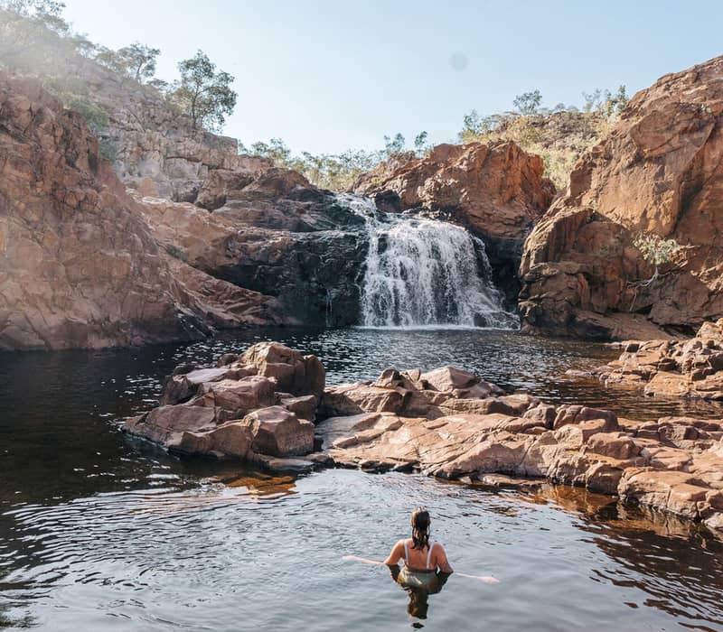 Person swimming in calm waters near Edith Falls, Nitmiluk National Park.