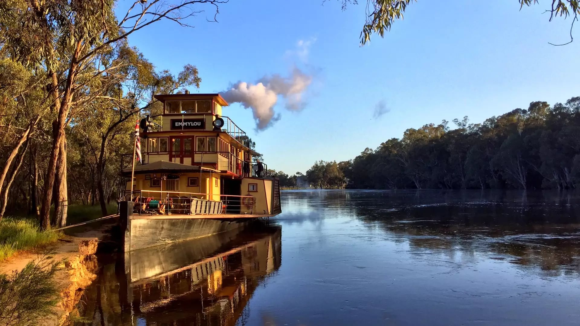 A peaceful golden hour reflection of the paddlesteamer PS Emmylou in the calm waters of the Murray River.
