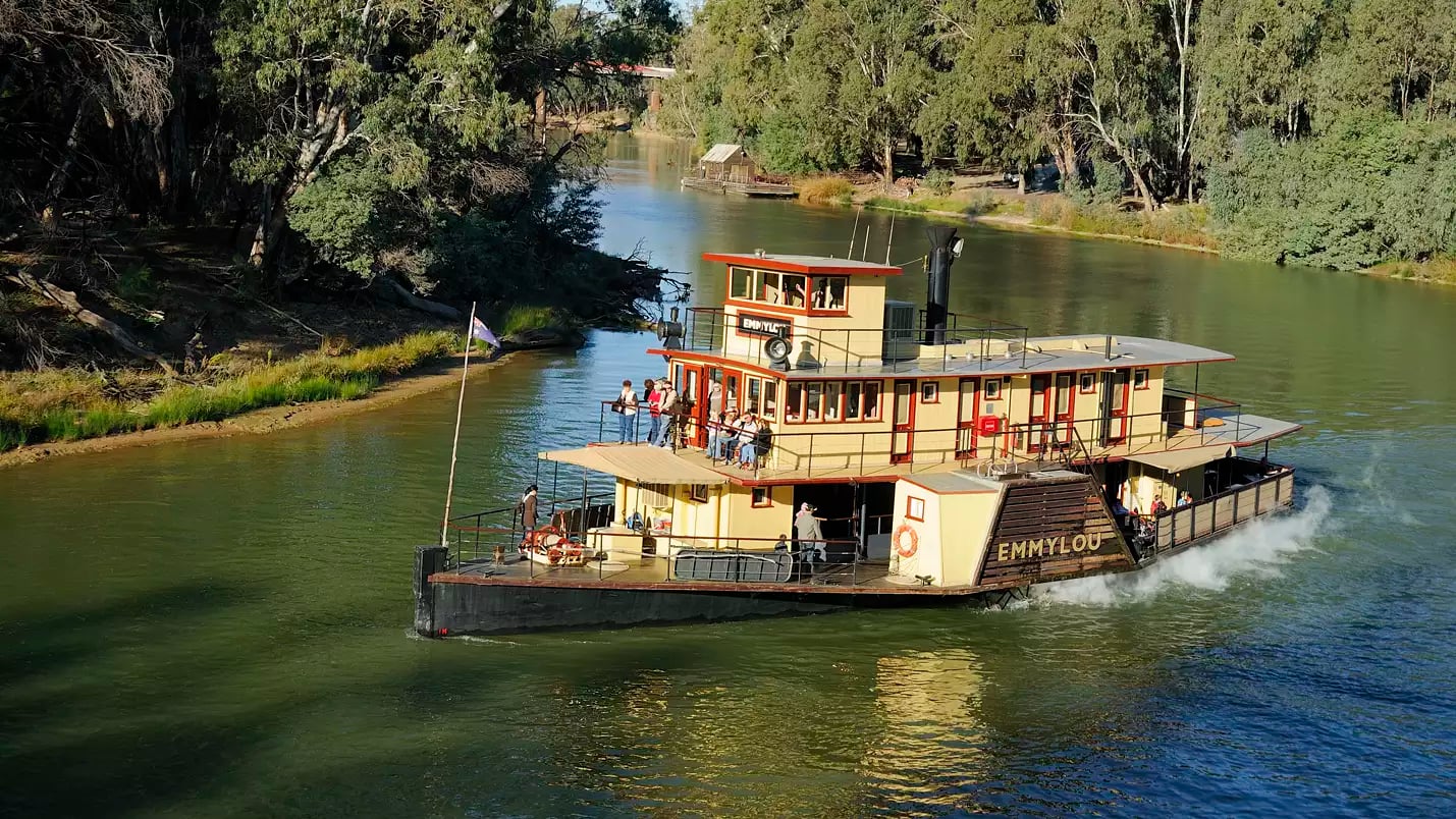 The historic paddlesteamer PS Emmylou with passengers on deck cruising on the Murray River near Echuca, Victoria.