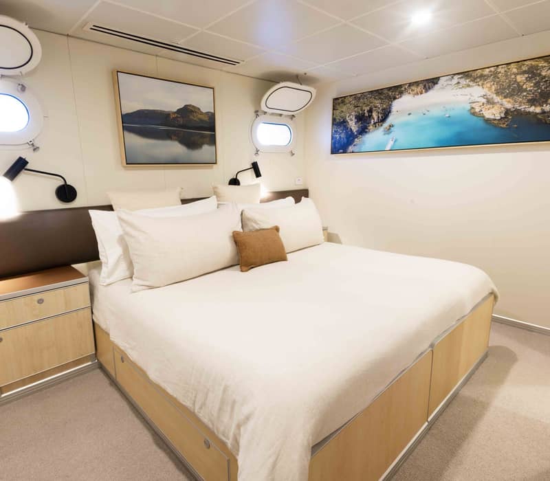 The white True North luxury expedition ship with an on-board helicopter parked on the top deck, sailing in the Kimberley region of Western Australia.