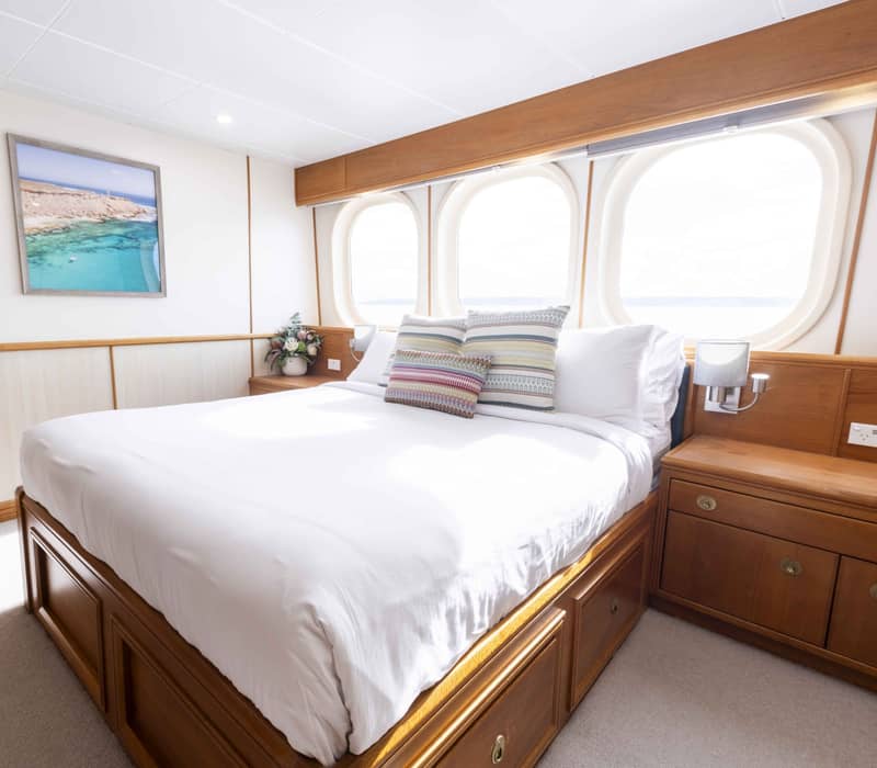 The white True North luxury expedition ship with an on-board helicopter parked on the top deck, sailing in the Kimberley region of Western Australia.