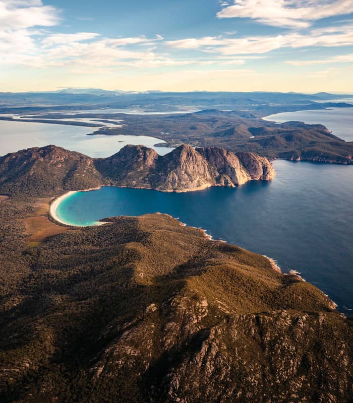 A stunning wide-angle aerial view of the Freycinet Peninsula, a highlight of any On Board Expedition Cruise in Tasmania.