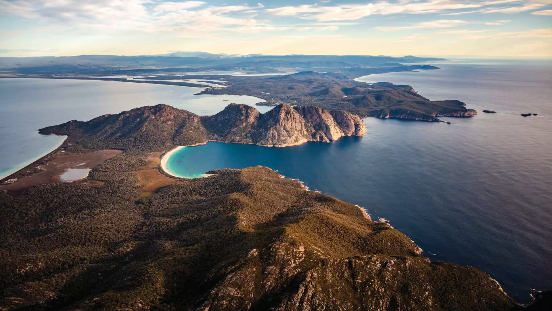 A stunning wide-angle aerial view of the Freycinet Peninsula, a highlight of any On Board Expedition Cruise in Tasmania.