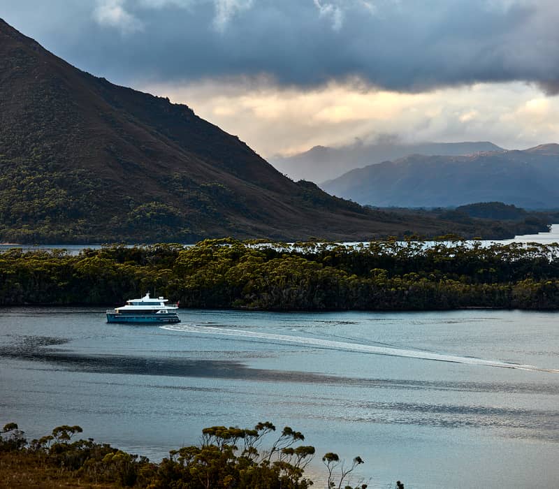 An On Board Expedition Cruise tender boat sets off for adventure from the Odalisque III in the remote wilderness of Tasmania.
