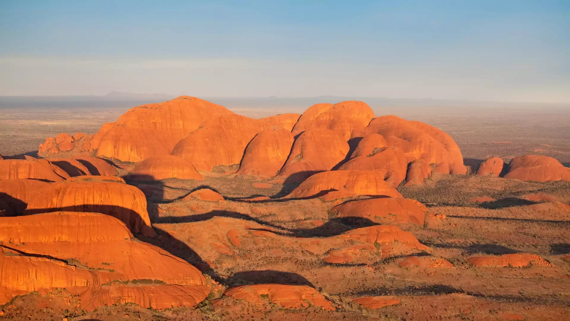 High-angle scenic shot of the red rock domes of Kata Tjuta during sunset in the Red Centre.